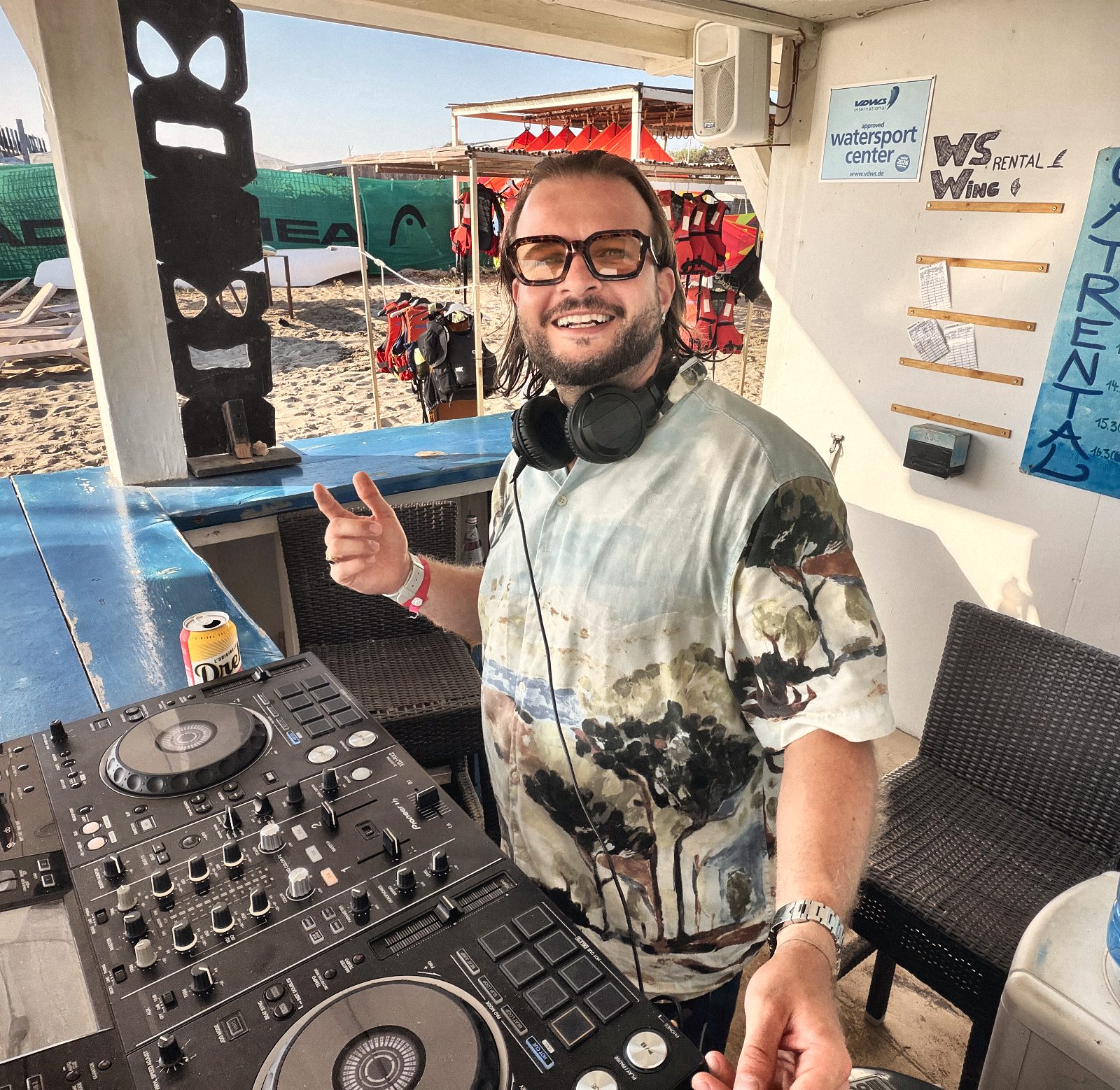 Guddy Gutierrez lachend am Pult einer Strandbar